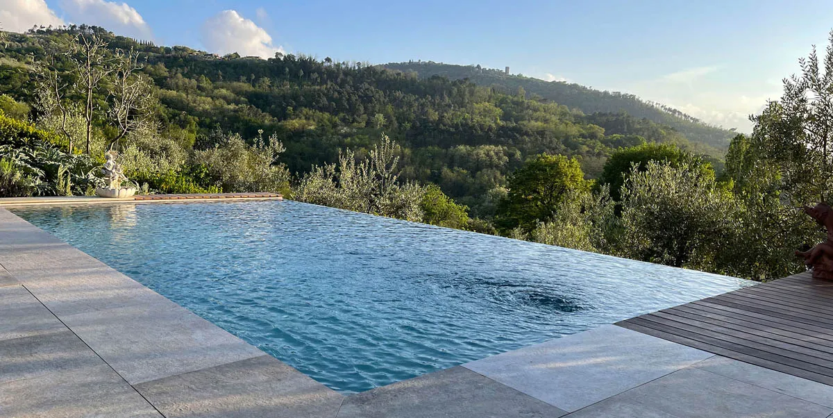 Splendida piscina a sfioro (infinity pool) integrata nel giardino di una villa di lusso in Costa Azzurra. Progettazione e costruzione piscine a Cap Ferrat.