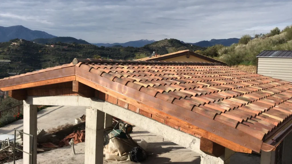Fase di posa delle tegole portoghesi sul tetto della villa in costruzione a Vallebona. Copertura tradizionale per la Costa Azzurra.