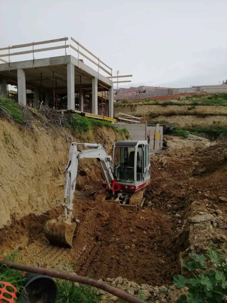 Miniescavatore Takeuchi al lavoro per scavi di fondazione in un cantiere edile in Via degli Inglesi a Bordighera.